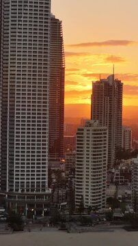 Aerial drone view of warm evening light on the Gold Coast high-rise apartments, Surfers Paradise, Queensland Australia - vertical video