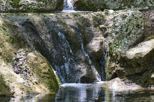 Small waterfall flowing over rocks in a wooded area, Butterfly Valley, Butterfly Valley, Rhodes, Dodecanese, Greek Islands, Greece