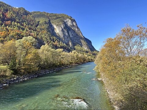 A clear river that snakes through an autumnal mountain landscape, under a clear sky, Drau, Drau cycle path, near Lienz, Tyrol, Austria