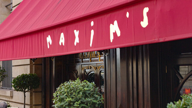 PARIS, FRANCE - SEPTEMBER 1, 2026 - Maxim's de Paris, a luxury restaurant, displaying its iconic red awning and entrance