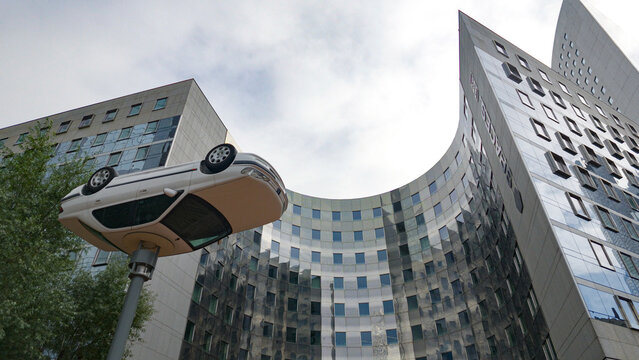 PARIS, FRANCE - SEPTEMBER 1, 2026 - Upside down car sculpture standing against modern architecture in La Defense, Paris