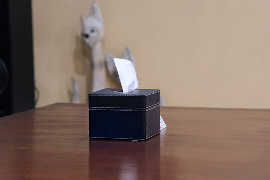 Sleek black faux leather square tissue box holder in empty wooden table