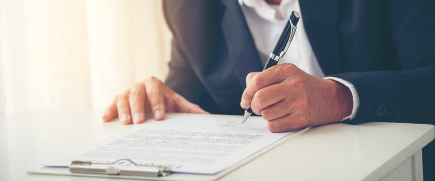 Banner Two Businessman signing contract document dealing teamwork. Banner Close up hand man colleagues  meeting mergers and acquisitions business. Partners Signed document at office with copy space