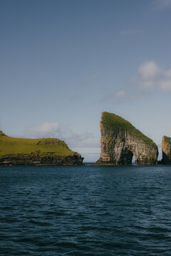Natural sea arch in the Faroe Islands with blue sky and copy space
