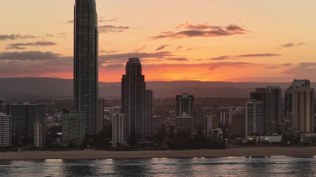 Surfers Paradise skyline at sunset seen from over the ocean, aerial drone footage, Gold Coast, Queensland Australia