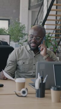 Multiethnic group of businesspeople working in office using computers talking on mobile phone. Workplace routine and diverse staff concept.