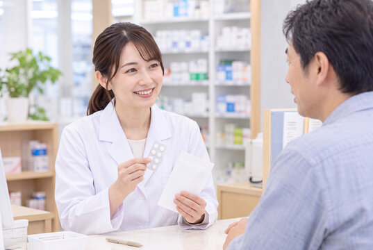 薬局で薬の服用方法を説明する女性薬剤師