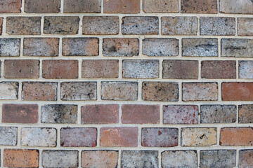 Obraz premium A full-frame view of a weathered brick wall featuring varied tones of red, grey, and brown bricks set in light mortar from the historic fortress walls in Prague.