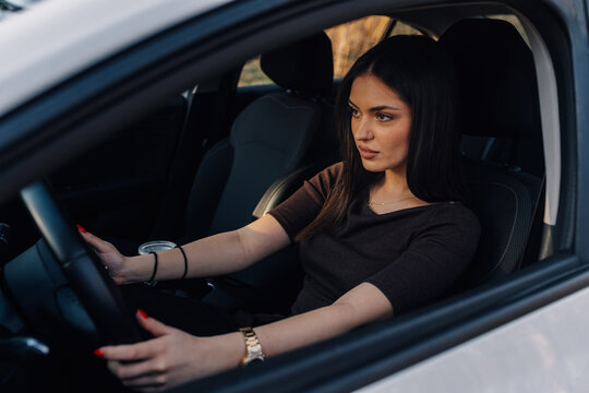 Young woman driving car, looking forward, commuting