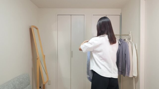 モーニングルーティン：シャツを選んで着替える女性