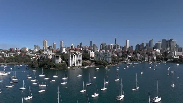 Sydney skyline from aerial view on beautiful sunny day. Camera tracks from Rushcutters Bay looking across to Elizabeth Bay and the Sydney CBD. Yachts and Motor Boats are on moorings.