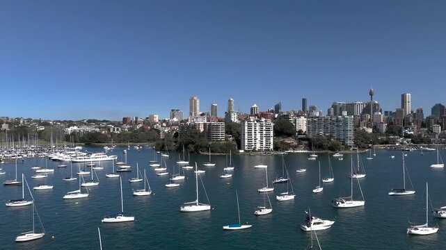 Sydney skyline from aerial view on beautiful sunny day. Camera pans left to Rushcutters Bay andd CYC from Elizabeth Bay. Yachts and Motor Boats are on moorings.