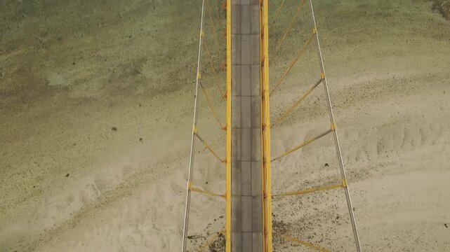 A bird's-eye drone shot tracks a motorbike as it crosses the Yellow Bridge near Nusa Lembongan, Bali