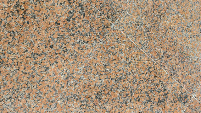 close-up, top-down view of polished granite tiles, characterized by a dense, mottled pattern of reddish-orange, black, grey, and white mineral grains