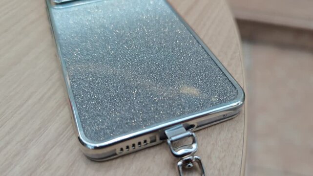 テーブルの上に置かれた銀色ケースのスマートフォン