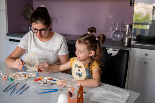 Mother and daughter paint Halloween pumpkin decorations