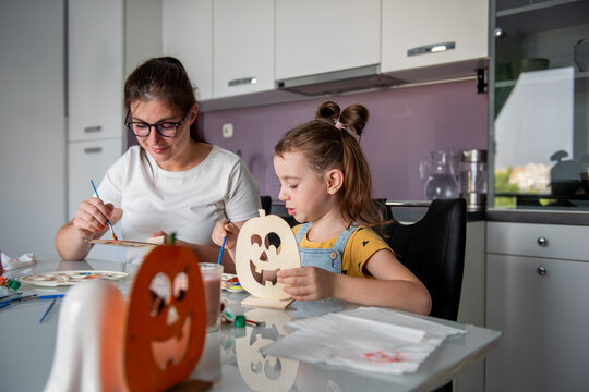 Mother and daughter make Halloween decorations at home