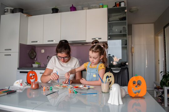 Mother and daughter make Halloween decorations at home