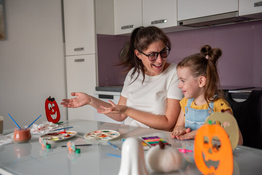 Mother and daughter make Halloween decorations at home