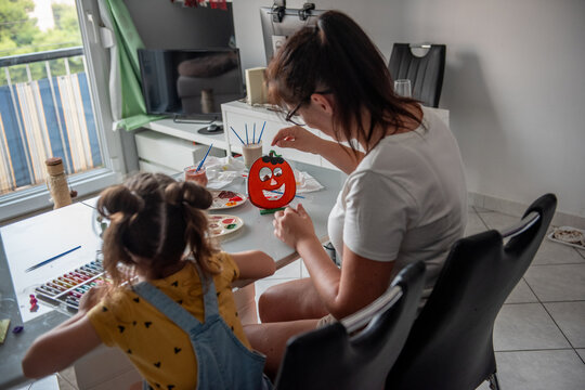 Mother and daughter make Halloween pumpkin decorations