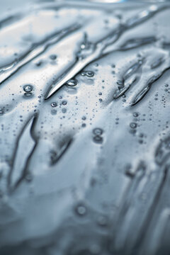 Translucent skincare gel texture with bubbles and glossy ripples