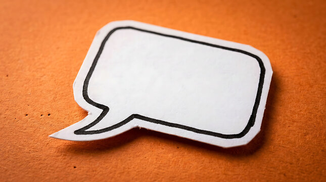 Blank white paper speech bubble cutout on a textured orange background.