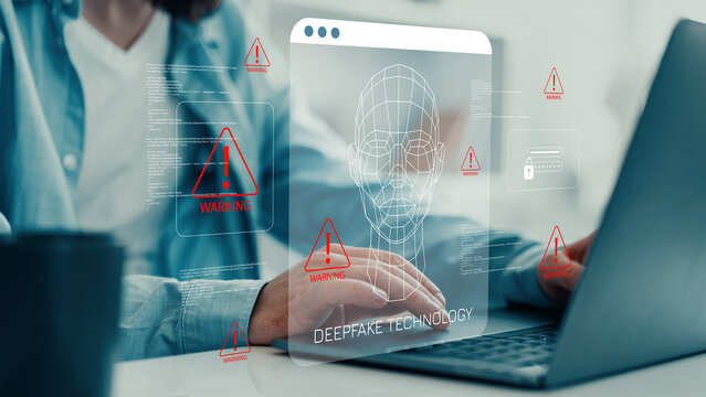 Display of deepfake technology on a laptop screen while a person works at a desk