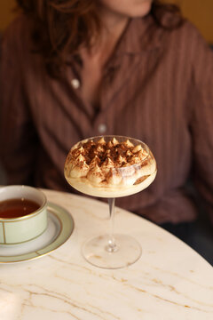 Italian Tiramisu Dessert in Glass Cup with Woman and Tea