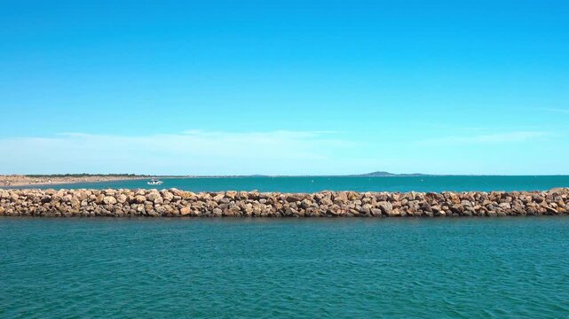 Boats are near a breakwater in open water. Valras, France .