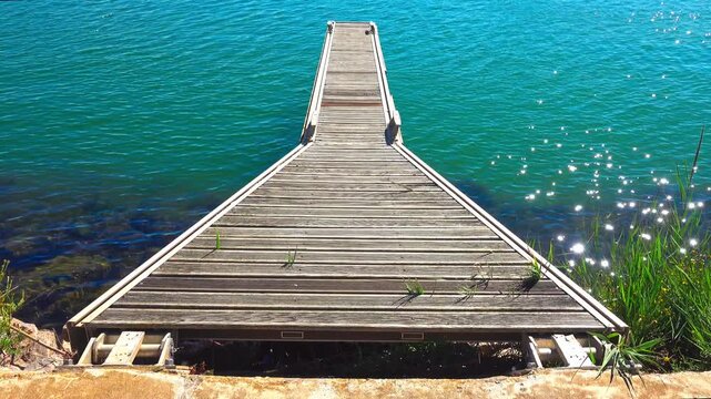 Dock by blue water with sunlight on river Orb. Valras, France