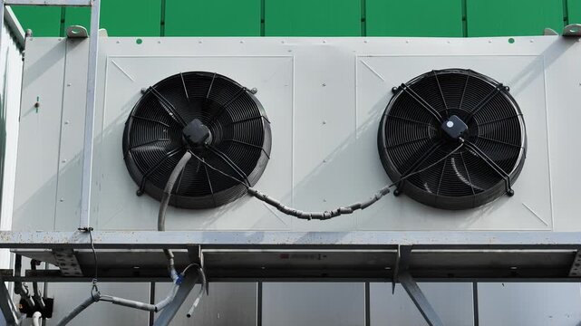 Industrial rooftop air conditioning unit with two fans cooling system on a building