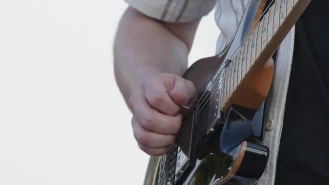 Guitarist demonstrates hybrid picking on electric guitar, isolated