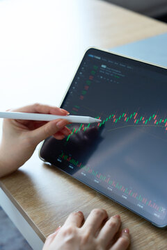 Woman's Hands Analyzing Stock Market Chart on Tablet