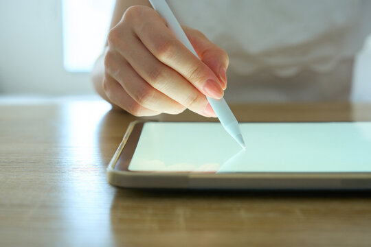 Young Womans Hand Writing on Digital Tablet with Stylus Pen