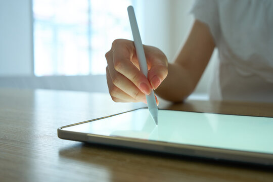 Young Womans Hand Writing on Digital Tablet with Stylus Pen
