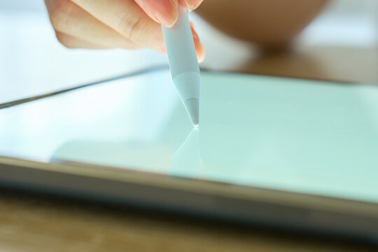 Young Womans Hand Writing on Digital Tablet with Stylus Pen