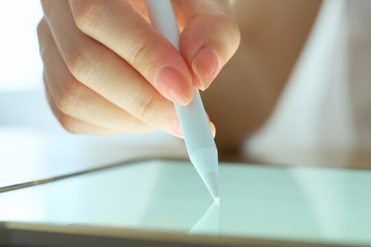 Young Womans Hand Writing on Digital Tablet with Stylus Pen