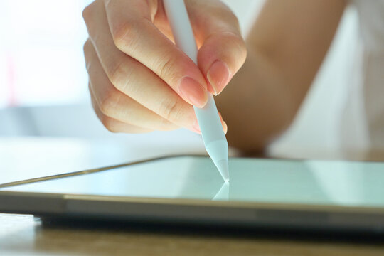 Young Womans Hand Writing on Digital Tablet with Stylus Pen