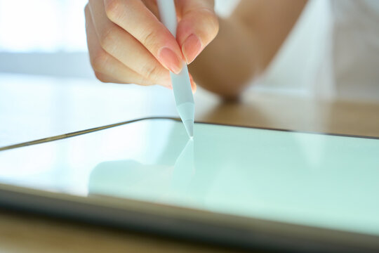 Young Womans Hand Writing on Digital Tablet with Stylus Pen