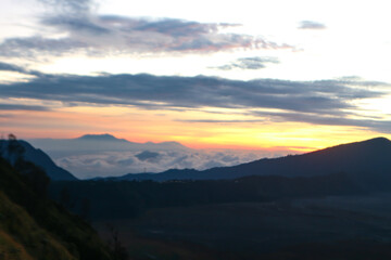 Obraz premium Scenic Mountain Sunrise Landscape with Sea of Clouds and Orange Dawn Sky