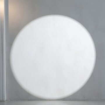 Circular light projection on a grey textured wall with spotlight effect round beam light circle concrete background wall texture lighting design spotlight