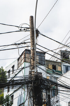 Utility pole entangled with wires in urban setting