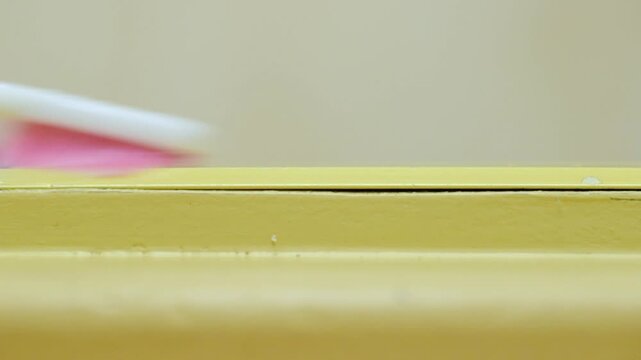 Gentle scrubbing of baseboard edges. Careful brushing technique for effective dirt removal. Systematic method of cleaning baseboards with detailed brushing approach
