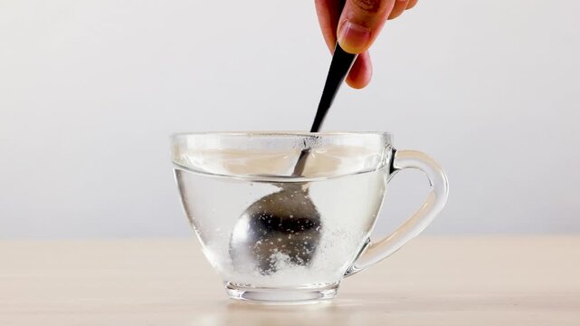 Stirring Sugar into Hot Water in a Glass Cup
