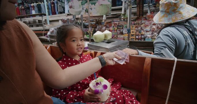 Family travel food and drink trip on wooden boat in Damnoen Saduak Floating Market Ratchaburi is one of the most popular floating markets in Thailand.
