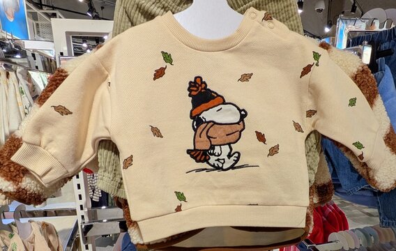 Tiempo de oto&ntilde;o. Sudadera para beb&eacute; con estampado de Snoopy de Peanuts, abrigado con gorro y bufanda mientras caen hojas de &aacute;rbol, en tienda de ropa Primark. Madrid, Espa&ntilde;a, 2 de septiembre de 2026