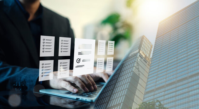 Businessman typing on laptop with virtual document checklist and report files on screen with building overlay. Concept of business workflow, document management, and quality control audit.