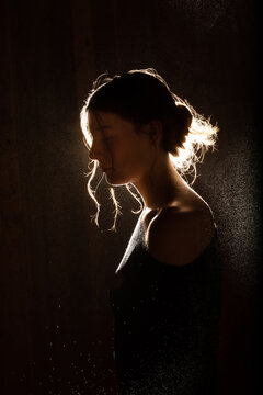 Contemplative teenager in profile with glowing rim lighting