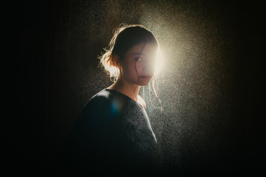 Woman looking over her shoulder in bright backlight