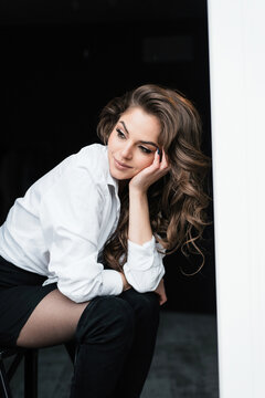 Thoughtful young woman in a white shirt daydreams